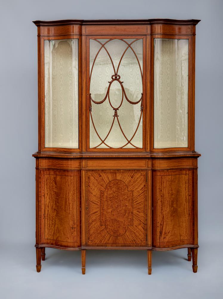 AN EDWARDIAN SATINWOOD DISPLAY CABINET of oblong serpentine form crossbanded with ebony chequer Image