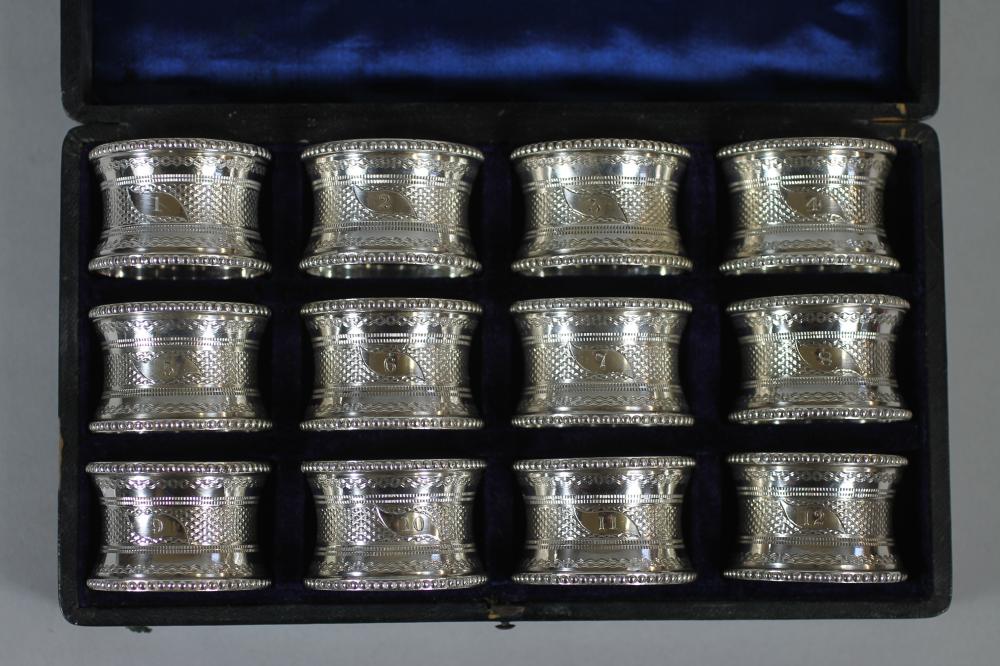 A SET OF TWELVE LATE VICTORIAN EPNS NAPKIN RINGS of waisted cylindrical form with bead cast borders Image