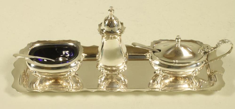 A SILVER THREE PIECE CRUET ON TRAY Image