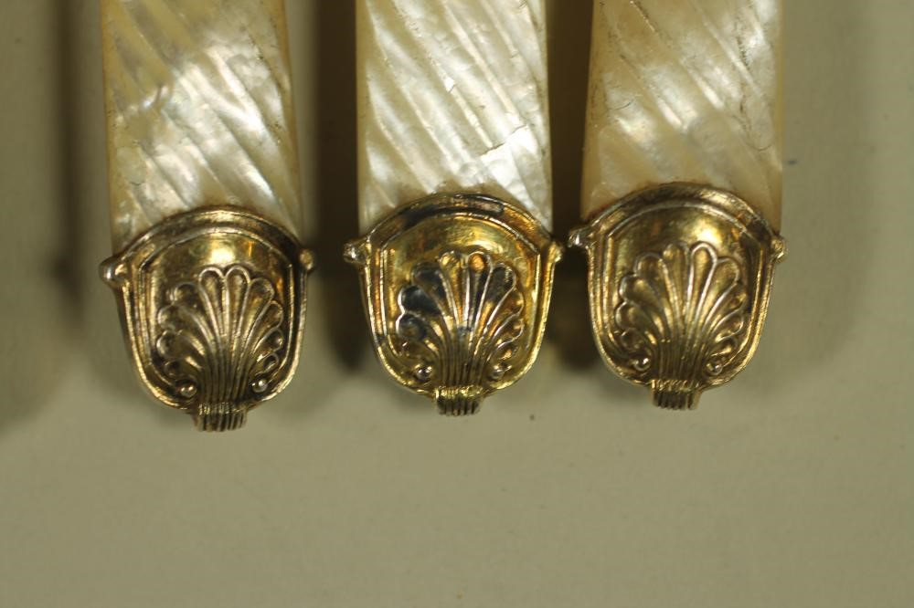 A PART SET OF LATE GEORGE III SILVER GILT DESSERT KNIVES AND FORKS Image