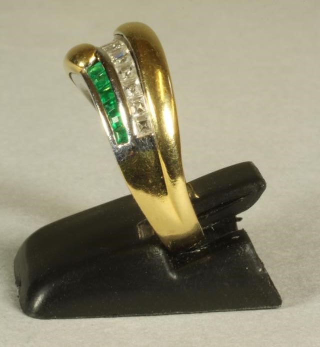 AN EMERALD AND DIAMOND FANCY HALF HOOP RING centred by a wavy band of channel set baguette cut Image