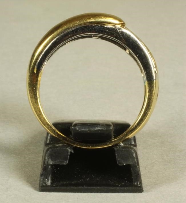 AN EMERALD AND DIAMOND FANCY HALF HOOP RING centred by a wavy band of channel set baguette cut Image