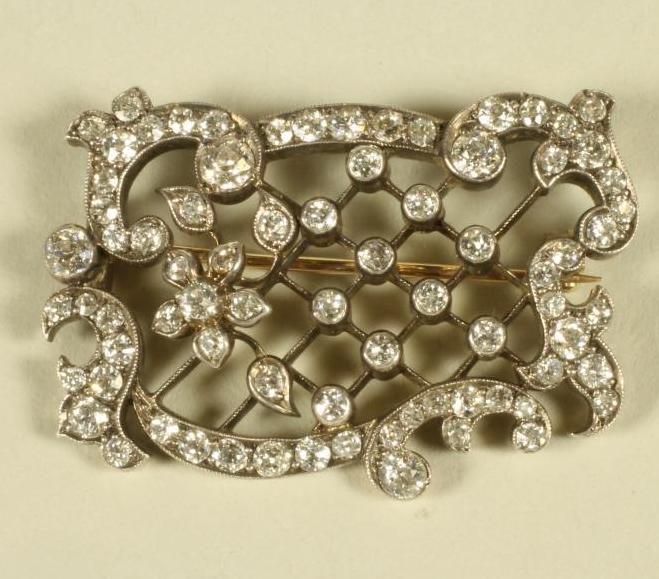 AN EDWARDIAN DIAMOND SET OPEN TRELLIS WORK PANEL BROOCH of rococo form Image