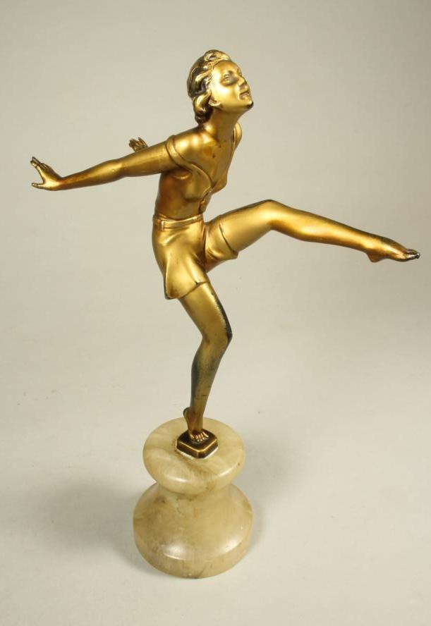 AN ART DECO BRONZED SPELTER FIGURE of a young woman wearing a sleeveless top and belted shorts Image