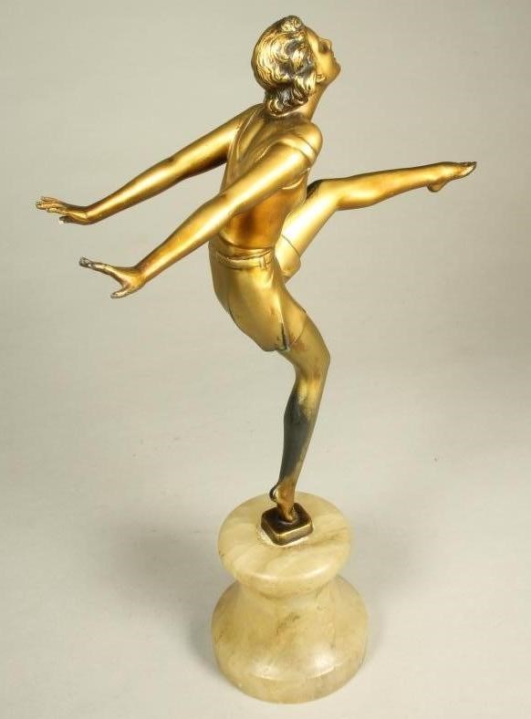 AN ART DECO BRONZED SPELTER FIGURE of a young woman wearing a sleeveless top and belted shorts Image