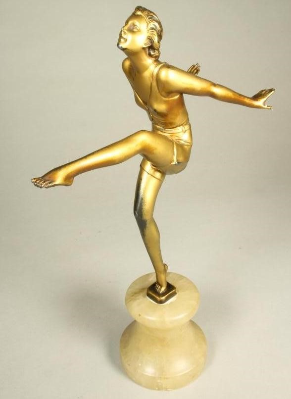 AN ART DECO BRONZED SPELTER FIGURE of a young woman wearing a sleeveless top and belted shorts Image