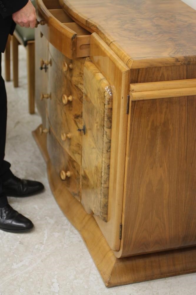 AN ART DECO BURR WALNUT DINING SUITE comprising extending dining table of rounded oblong form with Image