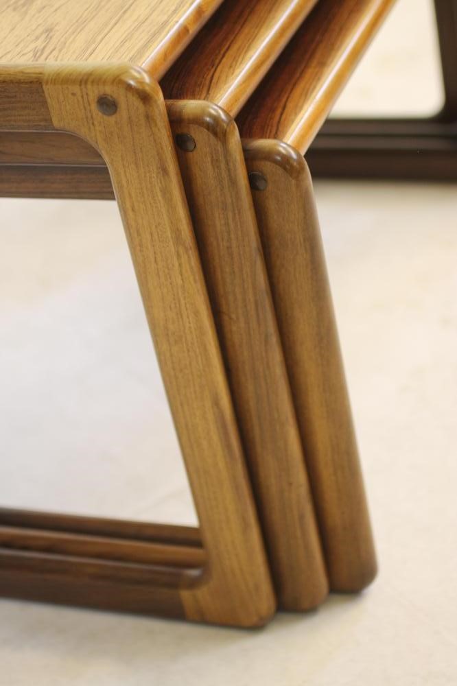 A NEST OF THREE ROSEWOOD TABLES Image