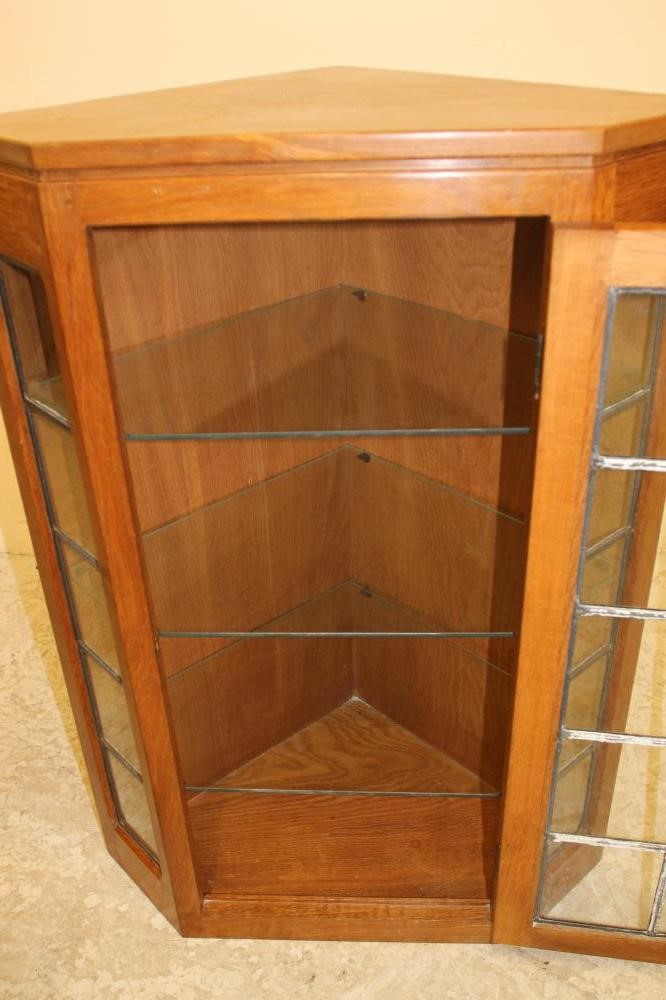 AN OAK AND LEAD GLAZED CORNER CUPBOARD BY ROBERT THOMPSON Image
