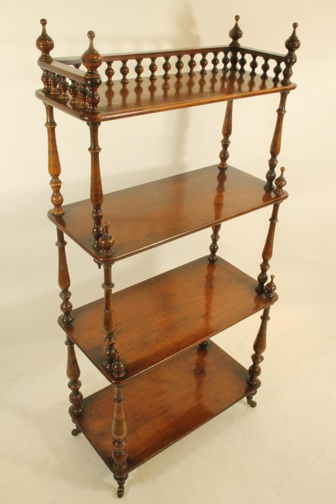A VICTORIAN WALNUT FOUR TIER WHATNOT of rounded oblong form with turned spindle three quarter Image