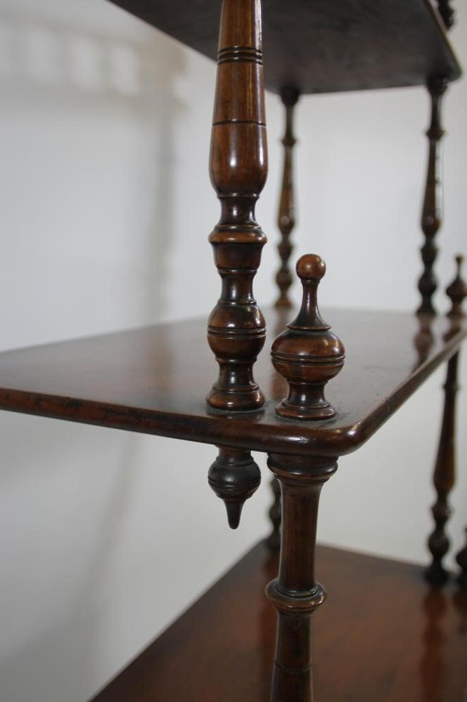 A VICTORIAN WALNUT FOUR TIER WHATNOT of rounded oblong form with turned spindle three quarter Image