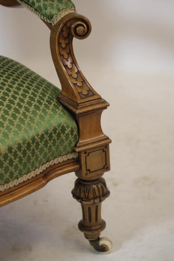 A VICTORIAN CARVED WALNUT SALON CHAIR of spoon back form button upholstered in green silk damask Image