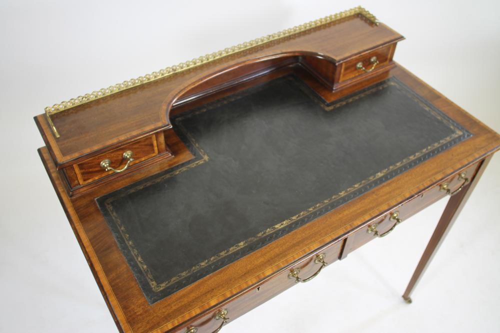 AN EDWARDIAN MAHOGANY WRITING TABLE of oblong form crossbanded with stringing Image