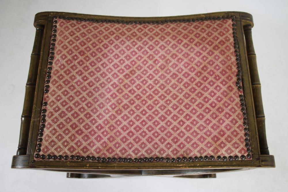 A REGENCY PAINTED X FRAMED STOOL of dished oblong form with faux bamboo side handles Image
