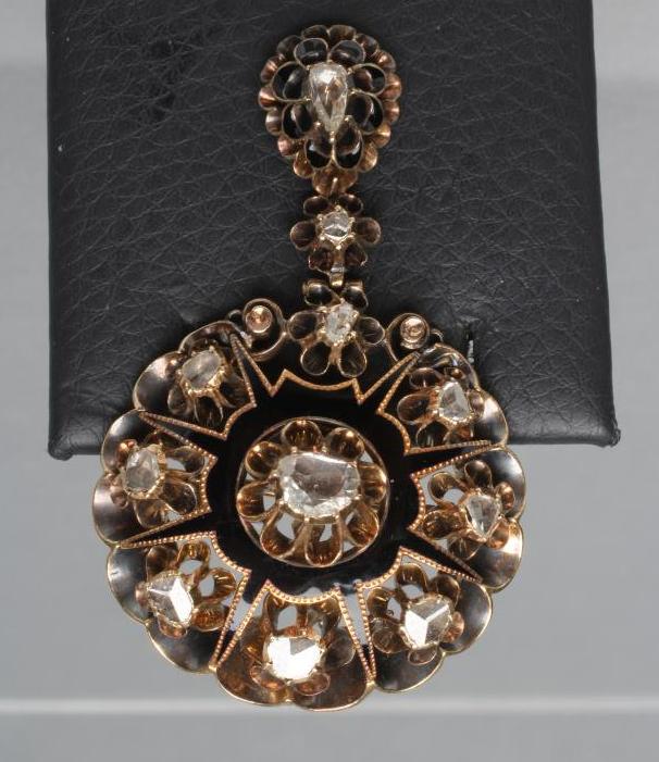 A VICTORIAN DIAMOND PENDANT/BROOCH claw set with eleven old mine cut stones within an unmarked black Image
