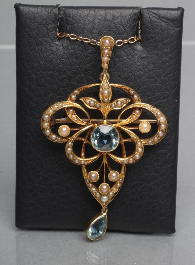 AN EDWARDIAN OPEN PENDANT/BROOCH centred by a collet set facet cut aquamarine and hung with a Image