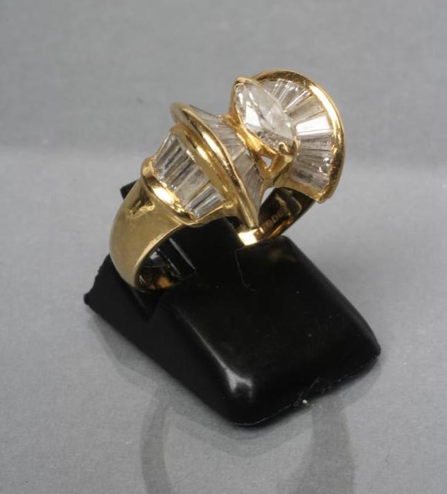 A MODERN DIAMOND DRESS RING centred by a marquise cut stone within a double bow border of baguette Image