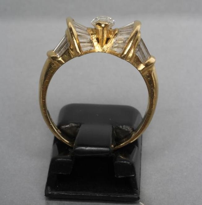 A MODERN DIAMOND DRESS RING centred by a marquise cut stone within a double bow border of baguette Image
