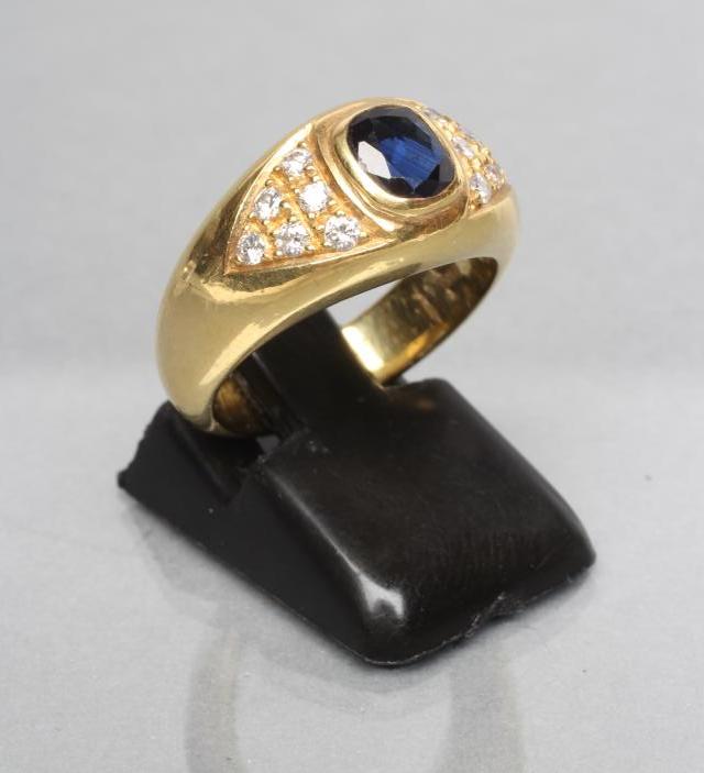 A SIGNET RING centred by a collet set cushion cut sapphire within triangular shoulder panels each Image