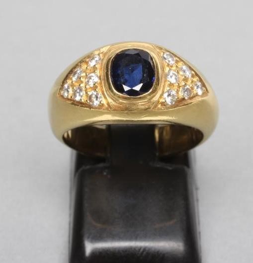 A SIGNET RING centred by a collet set cushion cut sapphire within triangular shoulder panels each Image