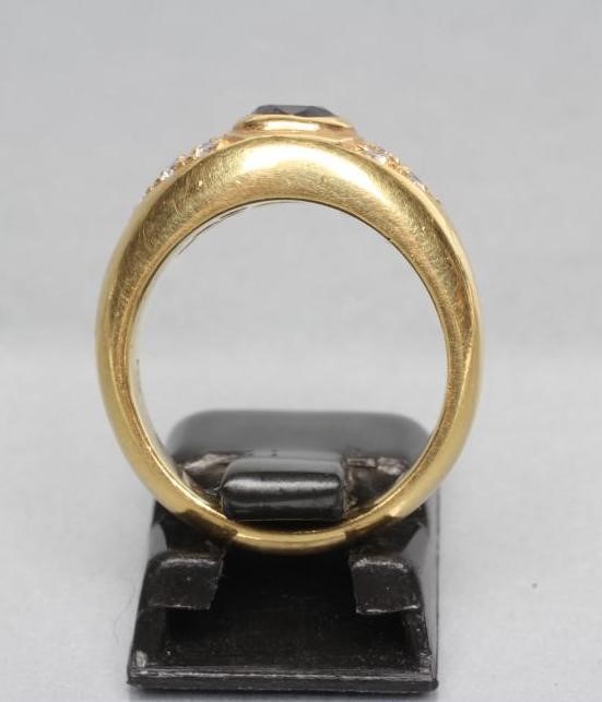 A SIGNET RING centred by a collet set cushion cut sapphire within triangular shoulder panels each Image