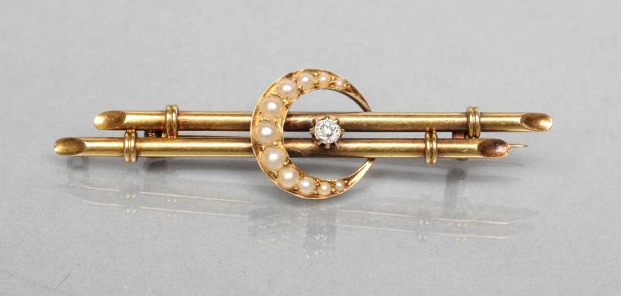 A LATE VICTORIAN DOUBLE BAR BROOCH centred by a small claw set diamond within a seed pearl crescent Image