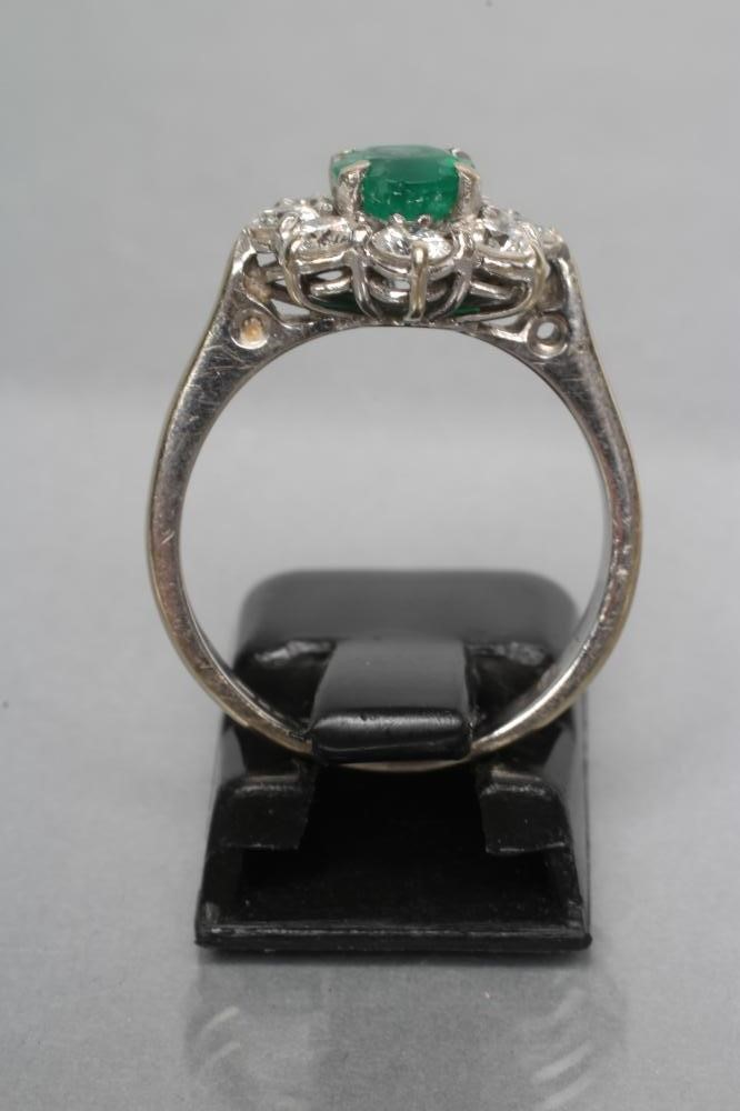 AN EMERALD AND DIAMOND CLUSTER RING Image