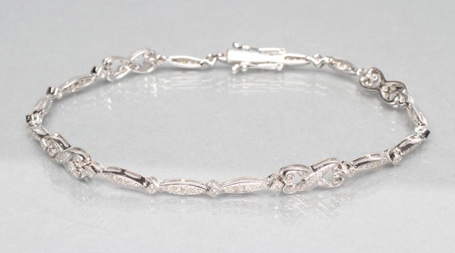 A DIAMOND BRACELET with four open scroll links tied by eliptical panels all pave set with small Image