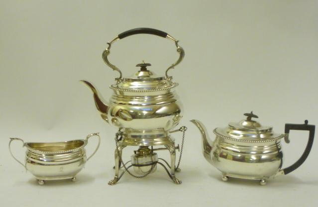 A SILVER TEA KETTLE AND BURNER ON STAND Image