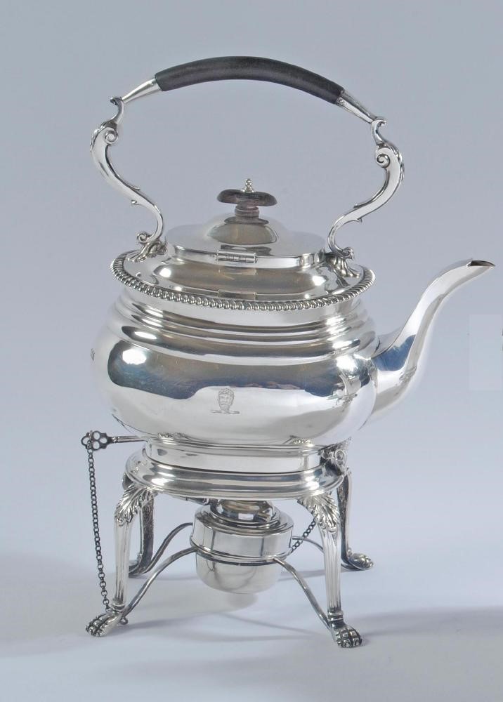 A SILVER TEA KETTLE AND BURNER ON STAND Image