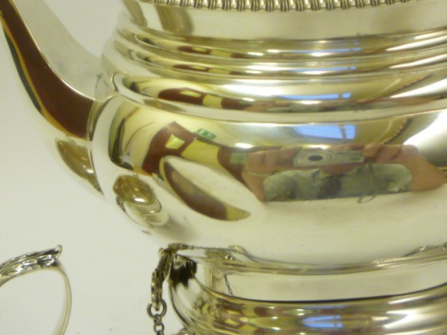 A SILVER TEA KETTLE AND BURNER ON STAND Image