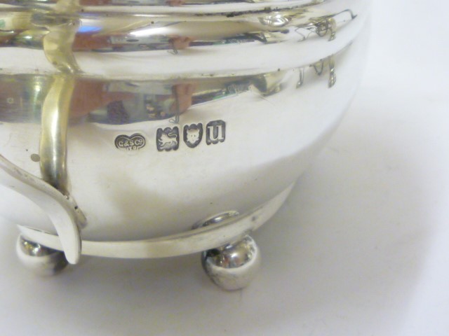 A SILVER TEA KETTLE AND BURNER ON STAND Image