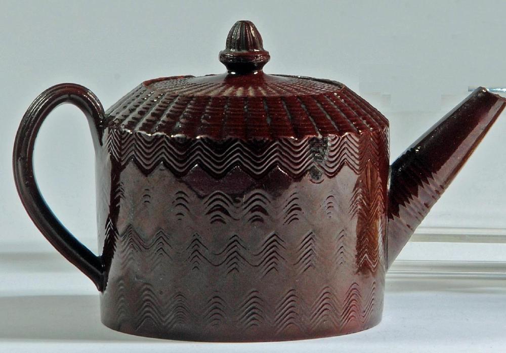 A STAFFORDSHIRE GLAZED RED-WARE TEAPOT AND COVER Image
