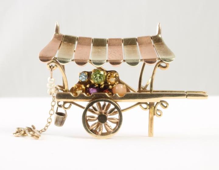 A 9CT GOLD NOVELTY BROOCH modelled as a flower seller's barrow with bi-coloured canopy Image