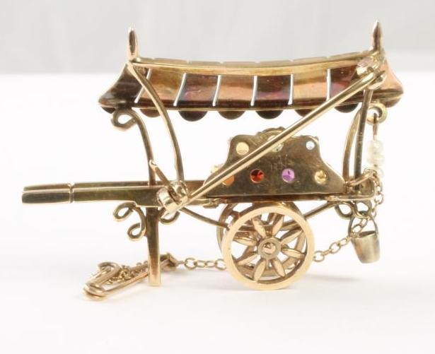 A 9CT GOLD NOVELTY BROOCH modelled as a flower seller's barrow with bi-coloured canopy Image