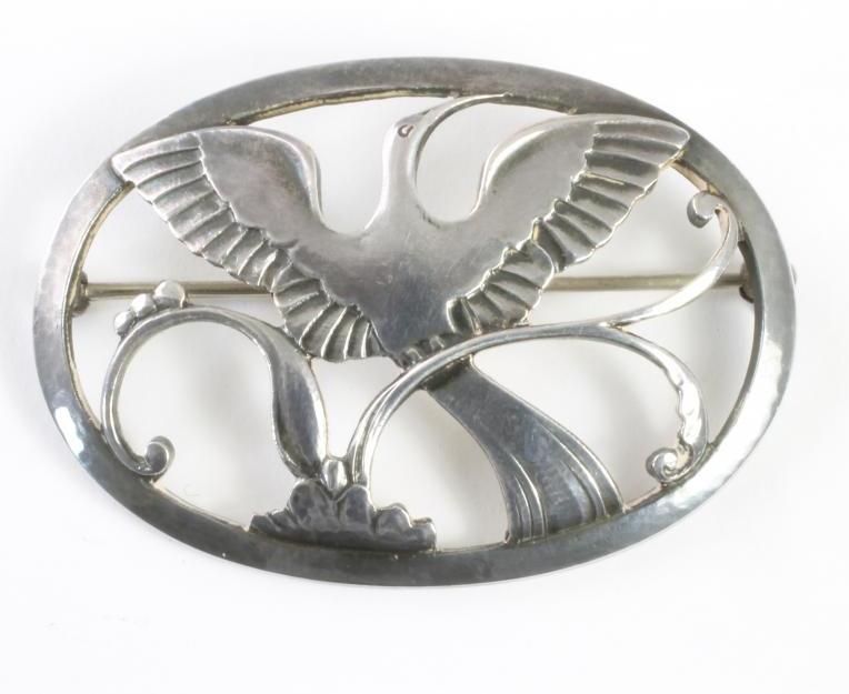 A GEORG JENSEN STERLING SILVER BROOCH of oval form centred by a crane in flight over stylised Image