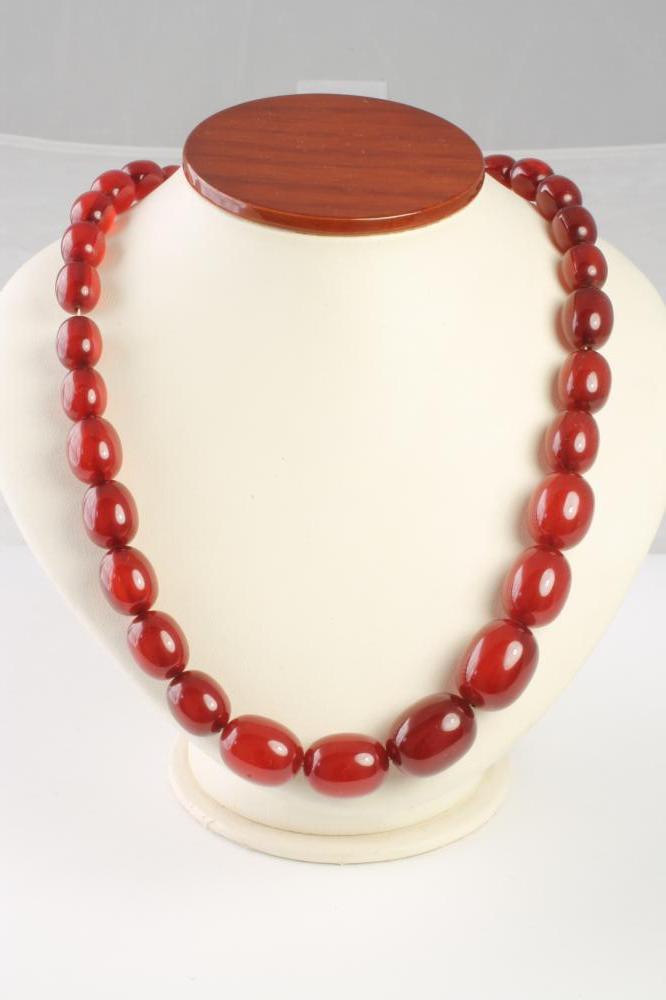 A SHORT STRING OF GRADUATED POLISHED AMBER BEADS Image