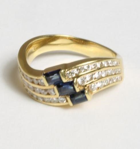 A SAPPHIRE AND DIAMOND HALF HOOP RING Image