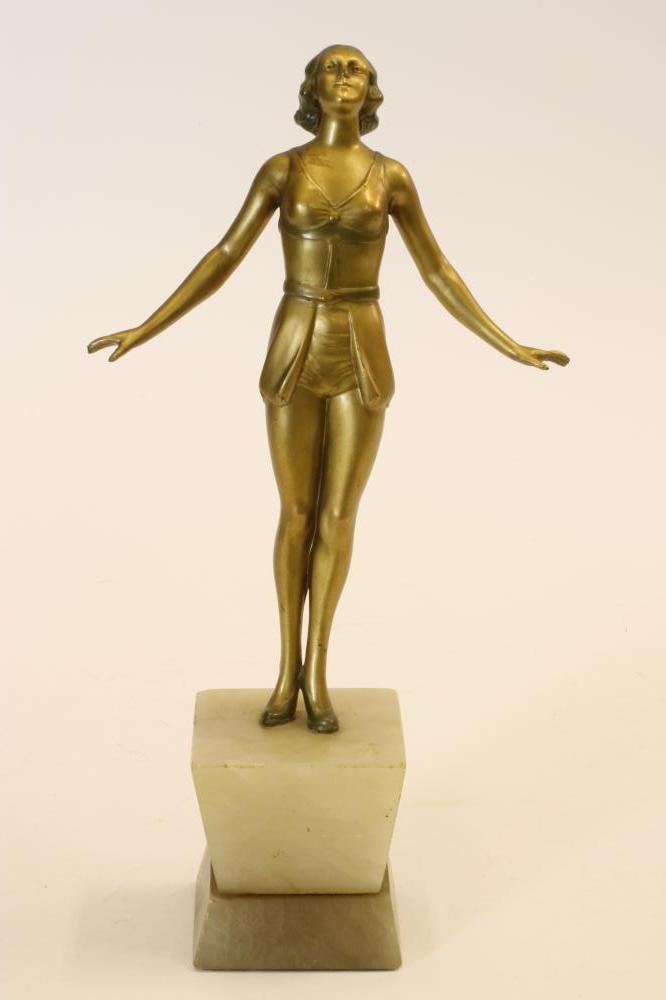 AN ART DECO BRONZED SPELTER FIGURE of a young girl wearing a bathing costume with belted skirt Image