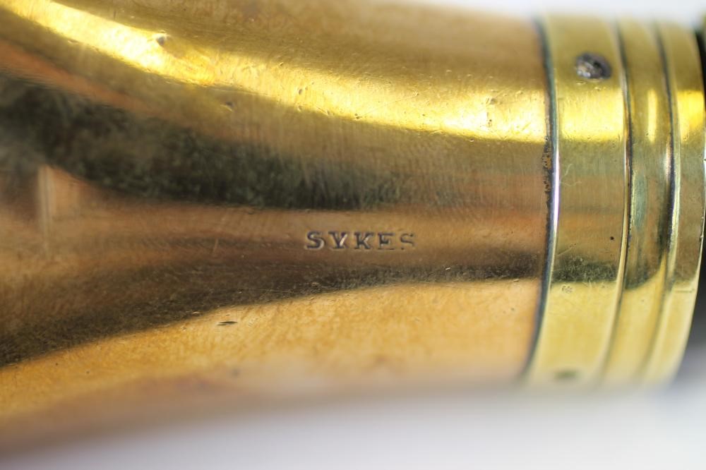 A BRASS PISTOL POWDER FLASK BY SYKES Image