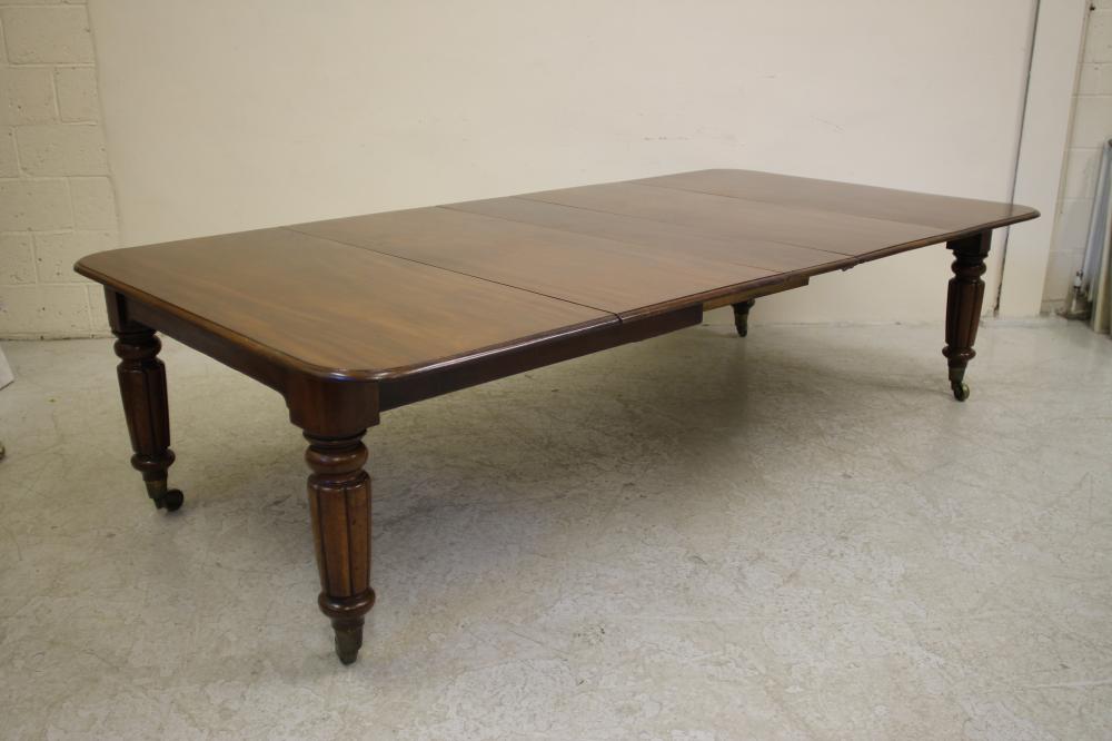 A VICTORIAN MAHOGANY EXTENDING DINING TABLE of rounded oblong form with pull out action and three Image