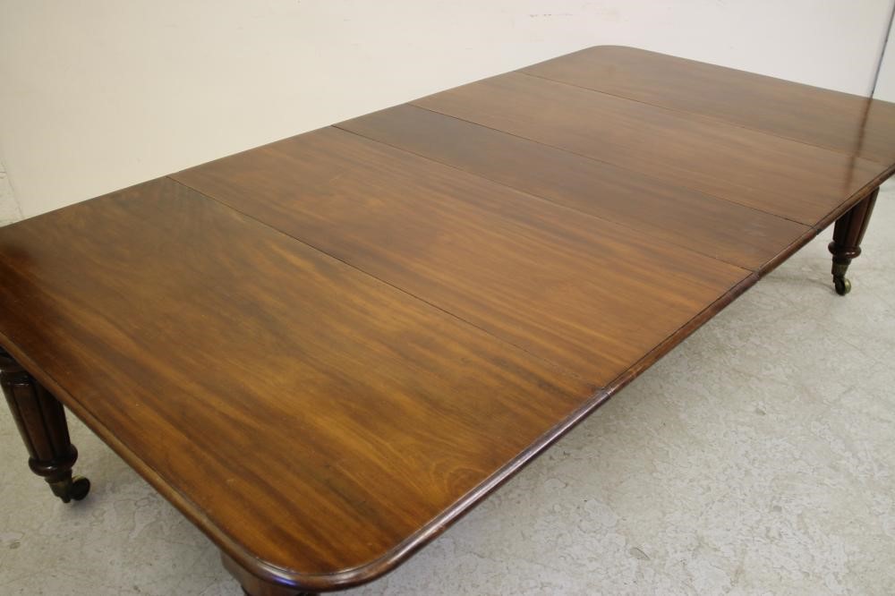 A VICTORIAN MAHOGANY EXTENDING DINING TABLE of rounded oblong form with pull out action and three Image