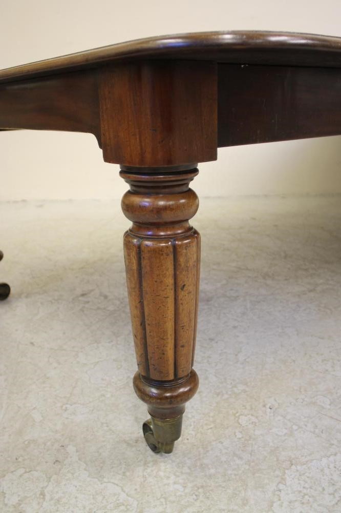 A VICTORIAN MAHOGANY EXTENDING DINING TABLE of rounded oblong form with pull out action and three Image