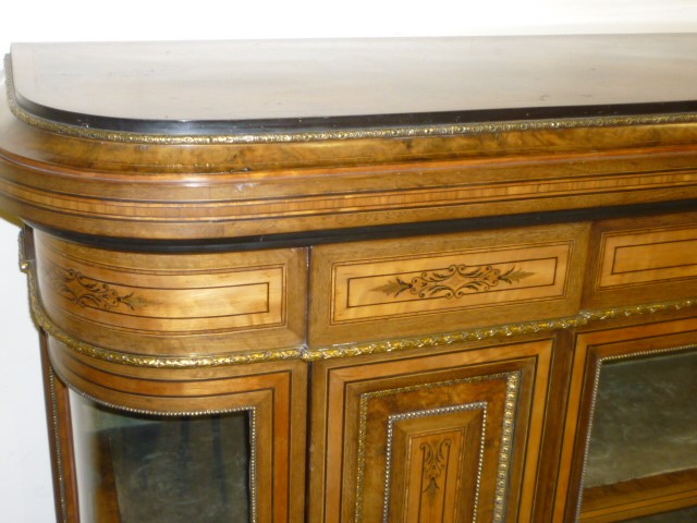 A VICTORIAN WALNUT AND EBONISED SIDE CABINET of rounded oblong form crossbanded with stringing and Image