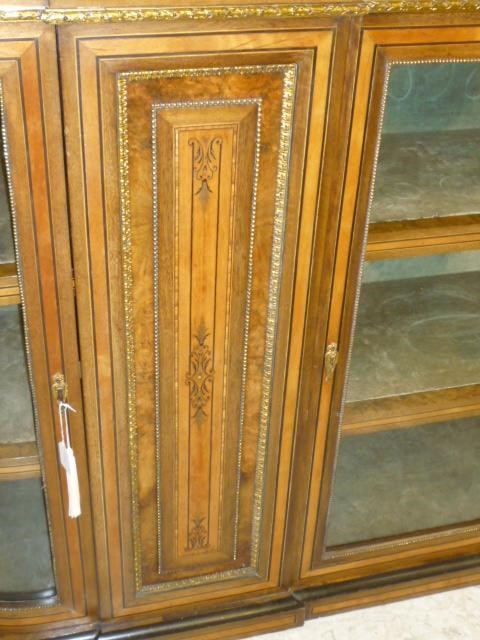 A VICTORIAN WALNUT AND EBONISED SIDE CABINET of rounded oblong form crossbanded with stringing and Image