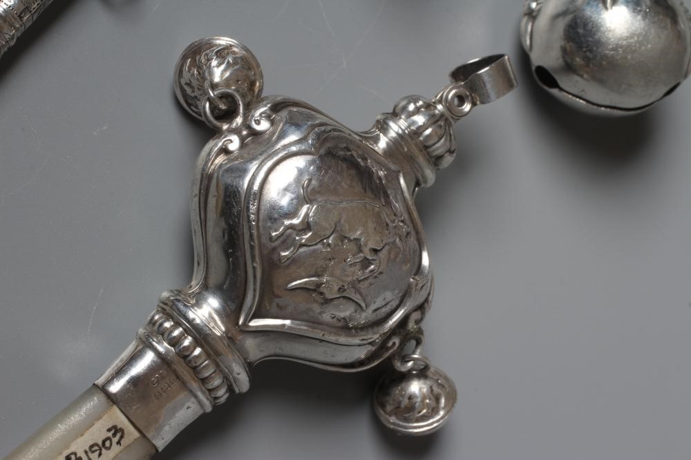FOUR SILVER RATTLES comprising an Edwardian dumbell by Saunders & Shepherd Image