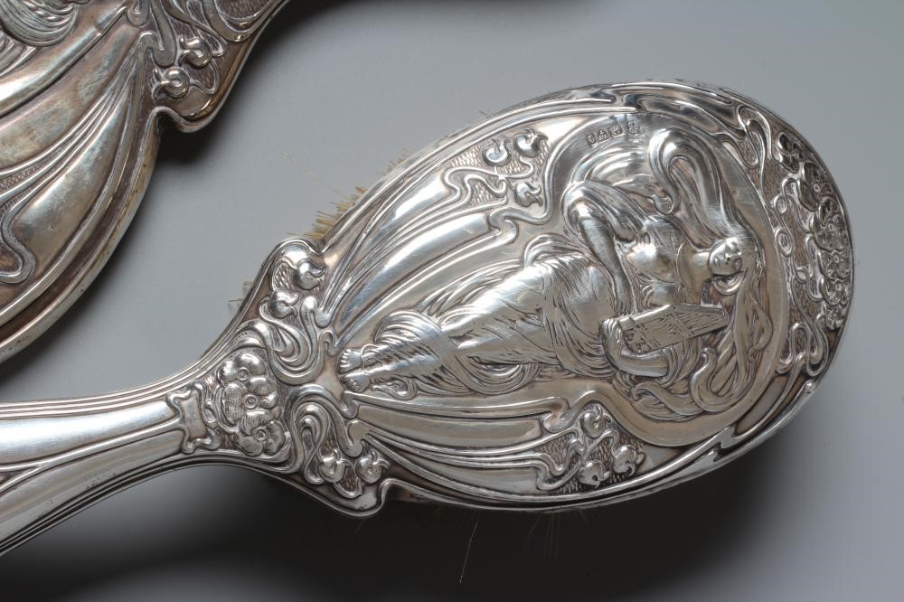 AN EDWARDIAN SILVER ART NOUVEAU HAND MIRROR AND MATCHING HAIRBRUSH by J & W Deakin, Chester 1903, Image