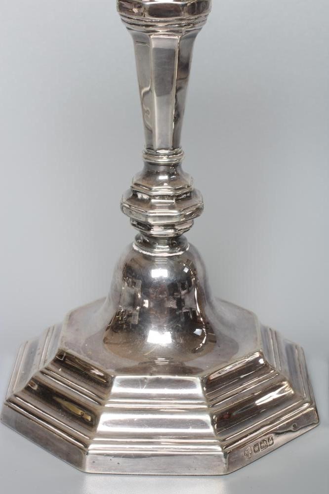 A COMPOSITE PAIR OF EDWARDIAN SILVER CANDLESTICKS by Hawksworth Image