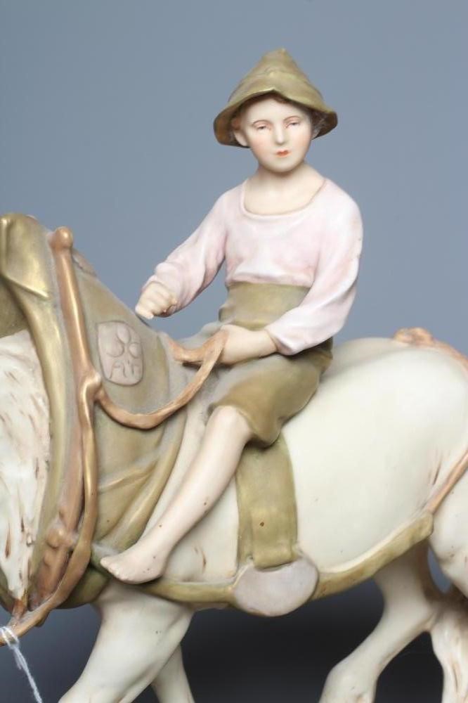 A ROYAL DUX SHIRE HORSE in harness and with a young boy in traditional garb seated astride, on a Image