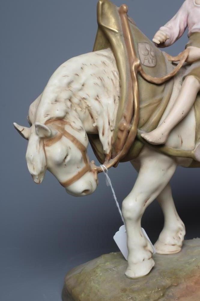 A ROYAL DUX SHIRE HORSE in harness and with a young boy in traditional garb seated astride, on a Image